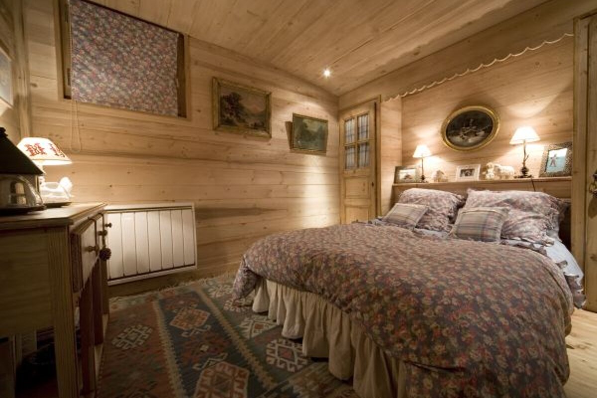 A bedroom with a large bed and a rug