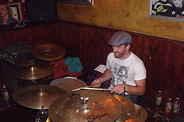 A man playing a drum set with zildjian cymbals