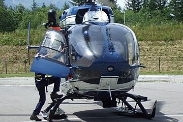 A blue and white helicopter is parked on the side of the road