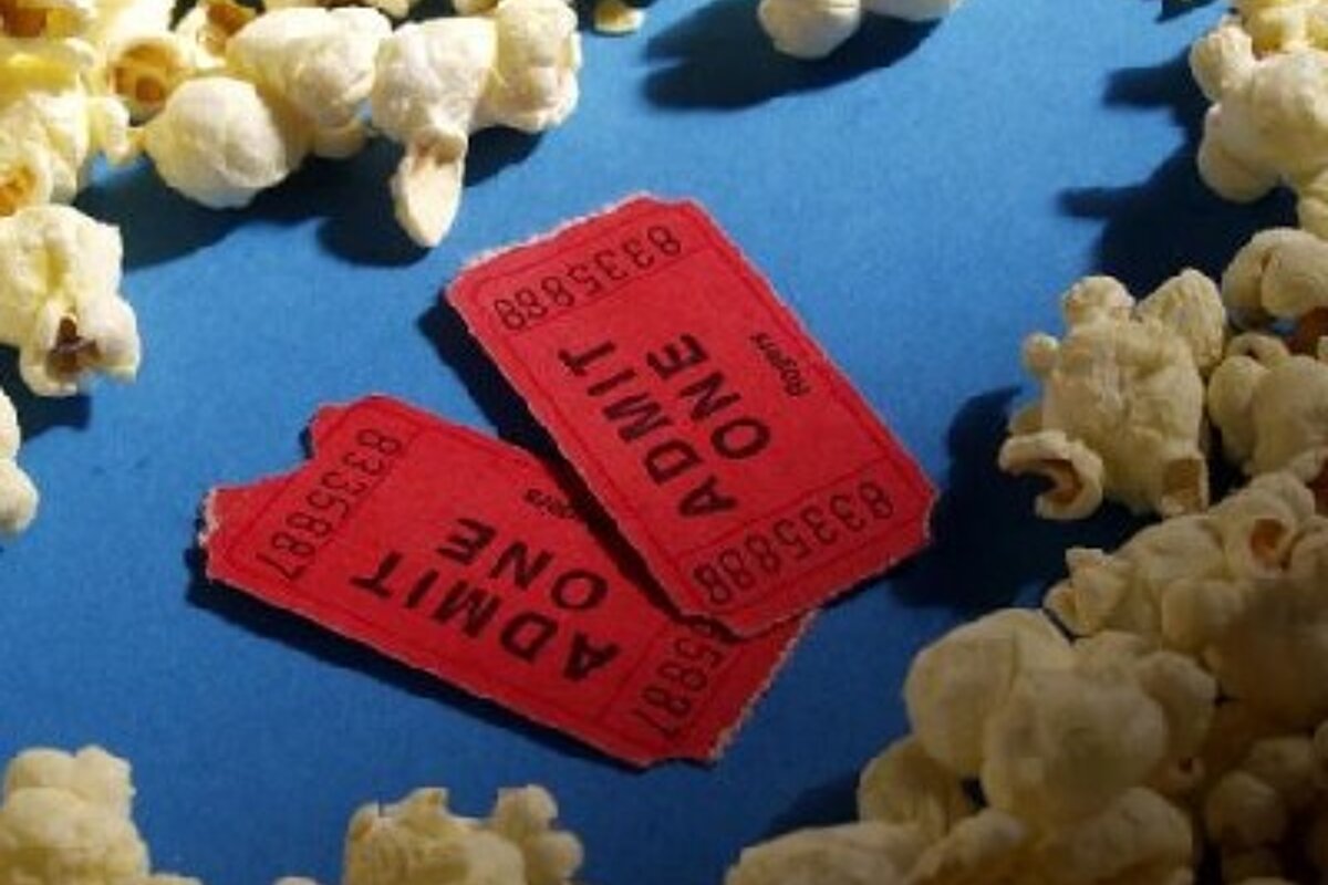 Two red admit one tickets are surrounded by popcorn