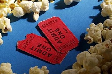 Two red admit one tickets are surrounded by popcorn