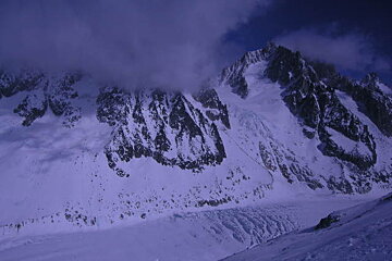 A snowy mountain with a blue sky in the background