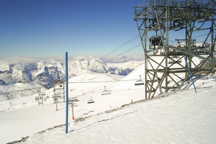 A ski lift on top of a snow covered mountain