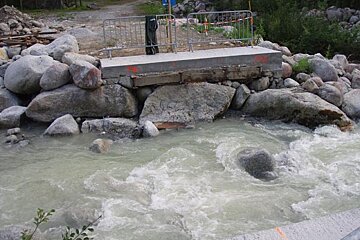 A bridge is being built over a river surrounded by rocks