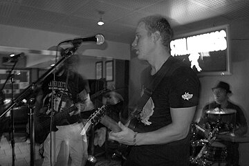 A man singing into a microphone wearing a shirt that says judge