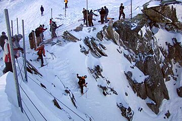 A group of people are skiing down a snowy mountain