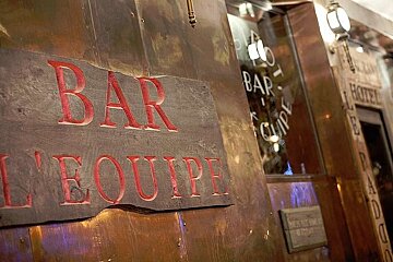 an image of a sign outside a bar on a wall showing the bars name