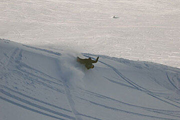 A person riding a snowboard down a snow covered slope
