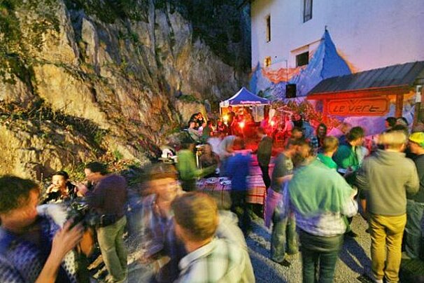 A crowd of people are gathered in front of a sign that says le verce