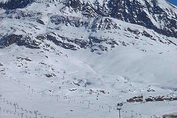 A snowy mountain with a ski resort in the foreground