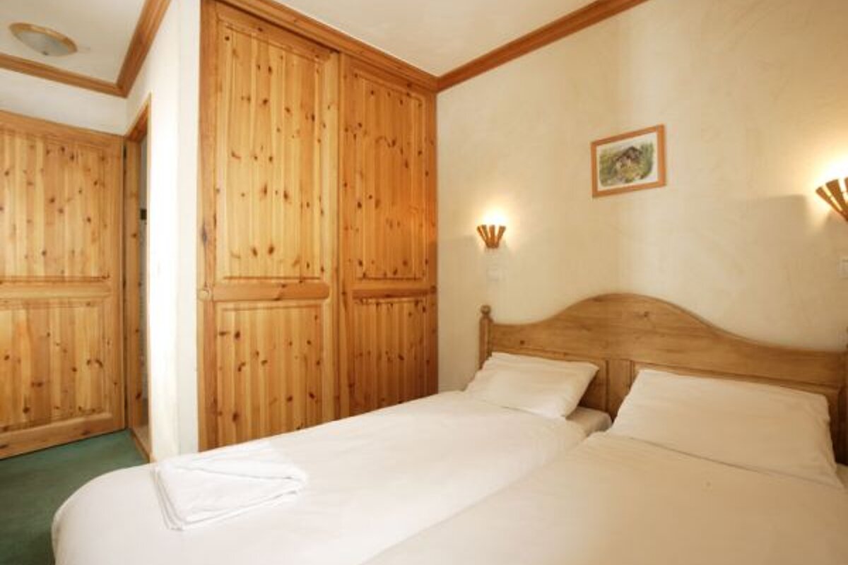 A bedroom with two beds and a picture on the wall