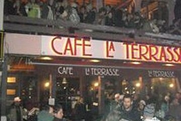 A crowd of people are gathered outside a restaurant called cafe la terrasse