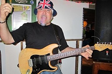 Singer performing and playing guitar in Saloon bar