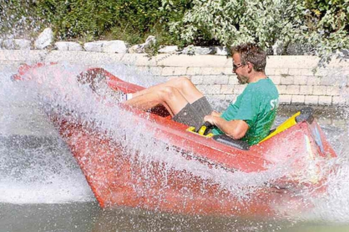 an image of a man in a red boat splashing in some water