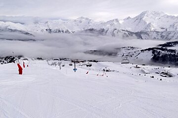 A snowy mountain with a ski lift in the distance
