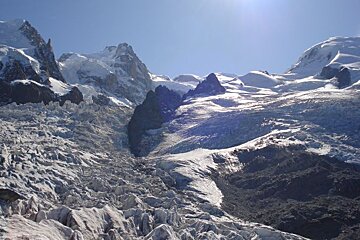 A snowy mountain with a blue sky in the background