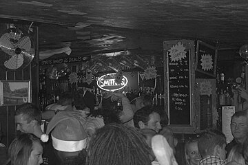A crowded bar with a sign that says smith on it