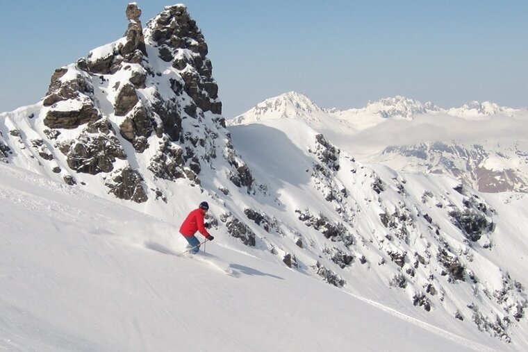 skier off-piste in powder by roc de tougne