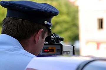 A police officer is taking a picture of a car with a camera