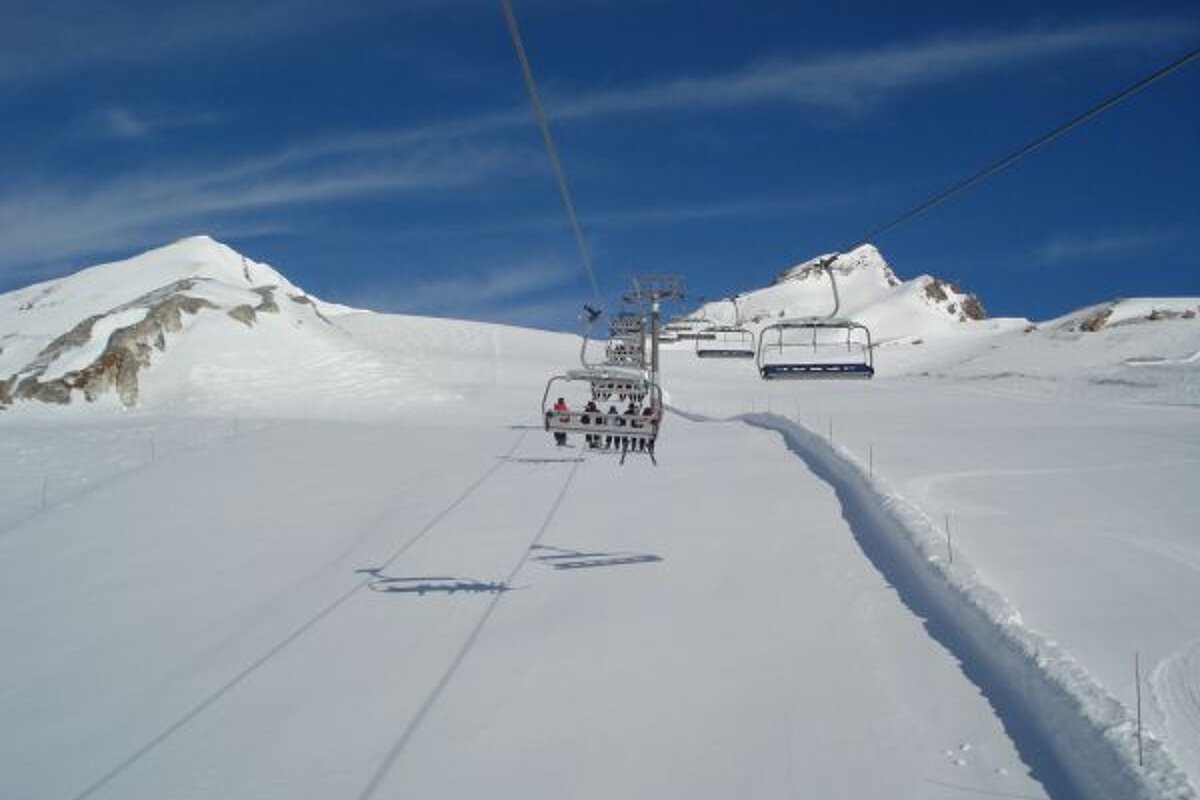A ski lift going up a snow covered mountain