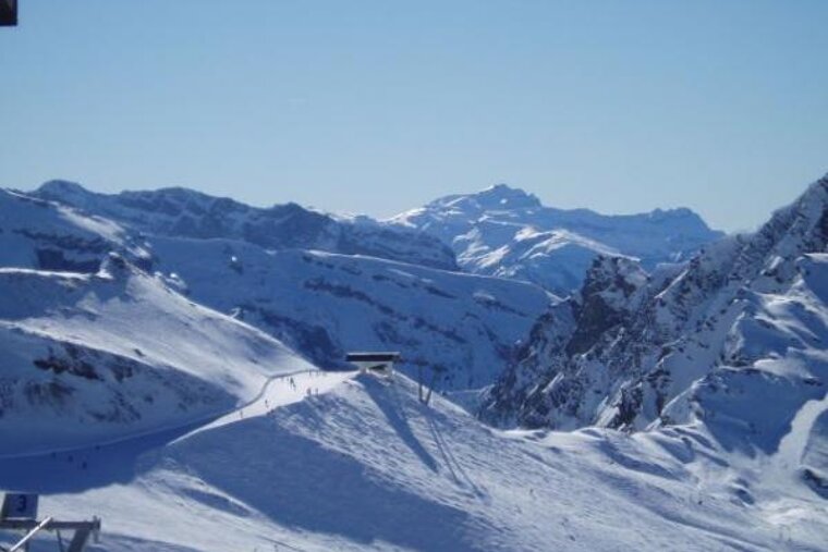 A ski lift is going up a snow covered mountain
