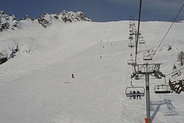 A ski lift going up a snow covered mountain