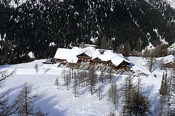 A large snow covered building in the middle of a snowy forest
