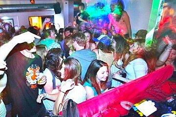 A large group of people are dancing in a club