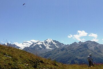 A paraglider is flying over a mountain range