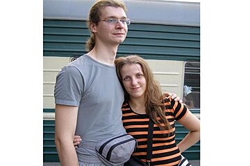 man with pony tail and glasses with female with long hair and strripey t-shirt