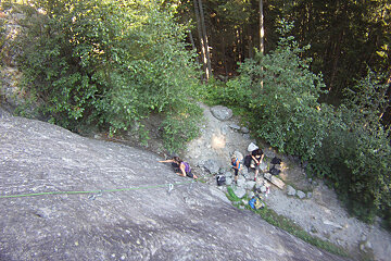 A group of people are climbing up a rocky cliff