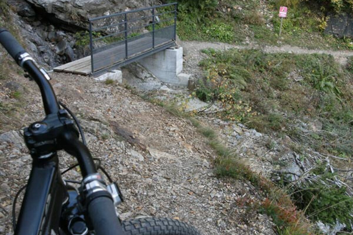 A bicycle is parked in front of a sign that says ' warning ' on it