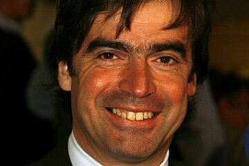 A man in a suit and tie smiles for the camera
