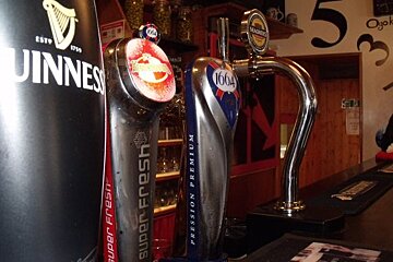 A guinness can sits next to a 1664 beer tap