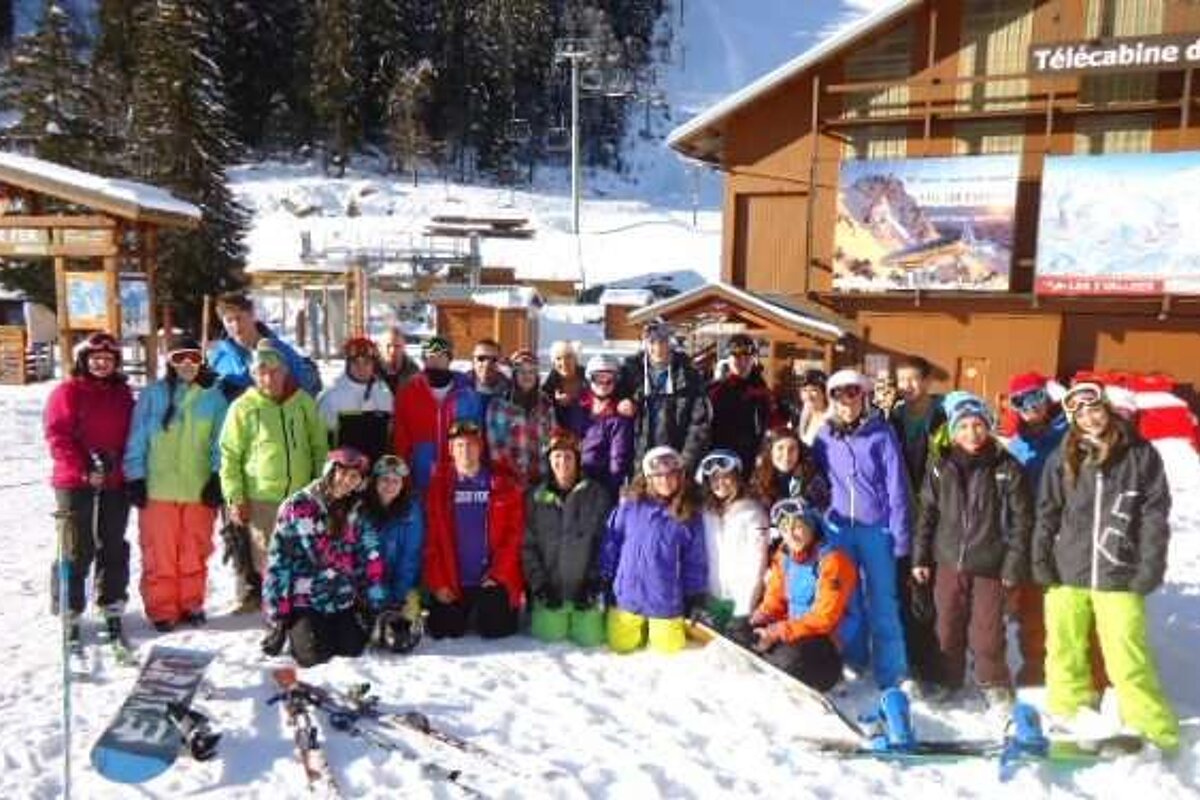 A group of people are posing for a picture in the snow