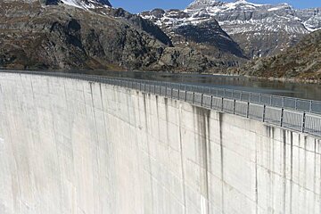 A large concrete wall with mountains in the background