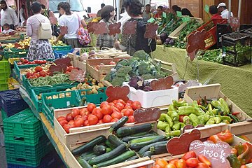 A display of vegetables with a sign that says " tomate " on it
