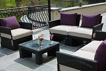 an image of garden furniture on a terrace with purple and cream cushions
