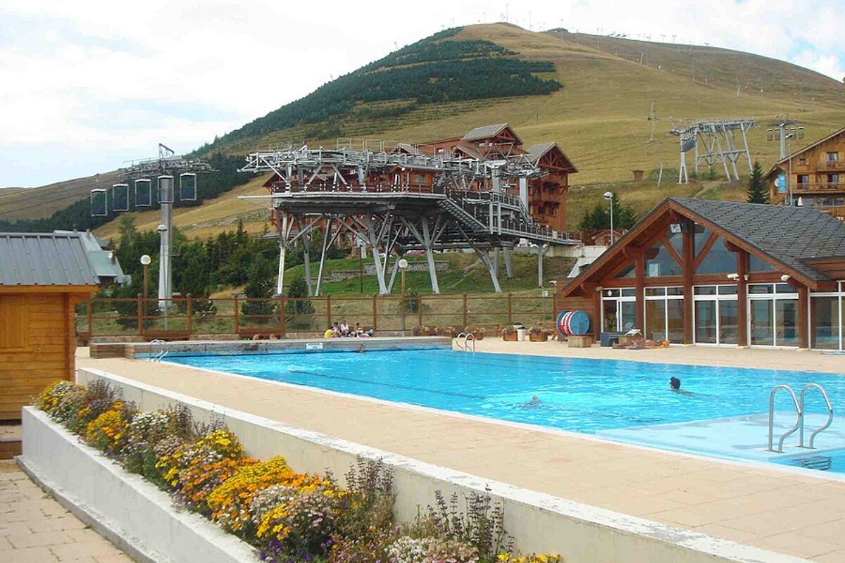 A swimming pool with a ski lift in the background