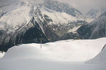 A snowy mountain with a ski lift in the foreground