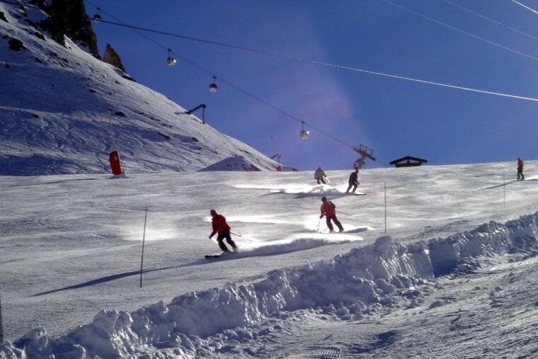 A group of people skiing down a snow covered slope
