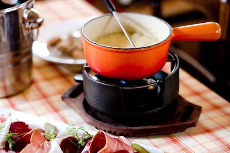 an image of a table with red and white cloth and a fondue sat on it