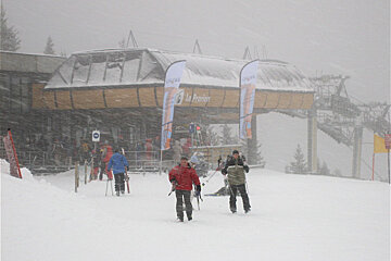 Skiers walking in front of a building that says la premiere