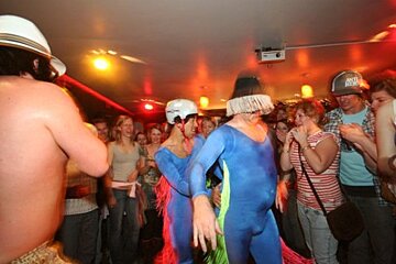 A man wearing a santa cruz hat stands in a crowd of people