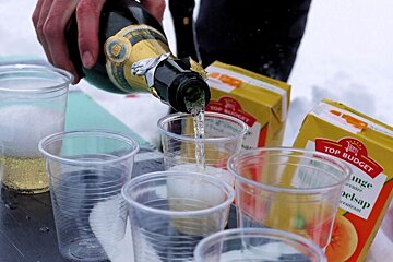 An image of champagne being poured on top of a snowboard