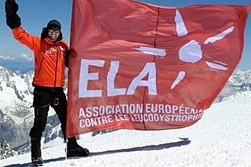 A person holding a red flag that says ela on it