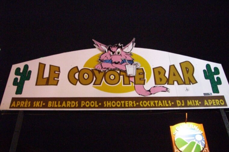 A sign for le coyote bar has a cartoon coyote on it