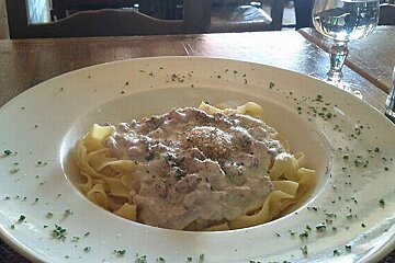 A plate of pasta with sauce and cheese on a table
