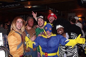 A group of men dressed in costumes pose for a photo