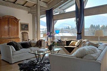 A living room filled with furniture and a large window with a view of the mountains